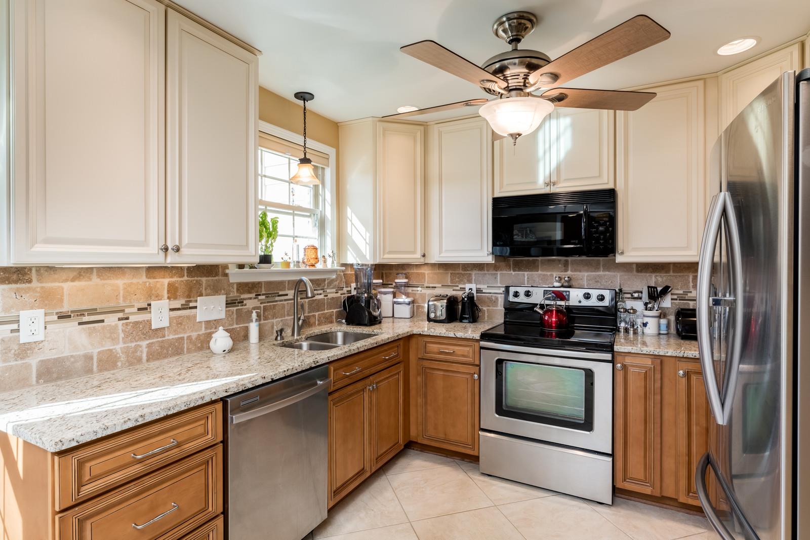1306 General George Patton Road, Unit 1306 Nashville, TN 37221 - Photo 4 of 21 a kitchen with stainless steel appliances a stove sink microwave refrigerator and cabinets