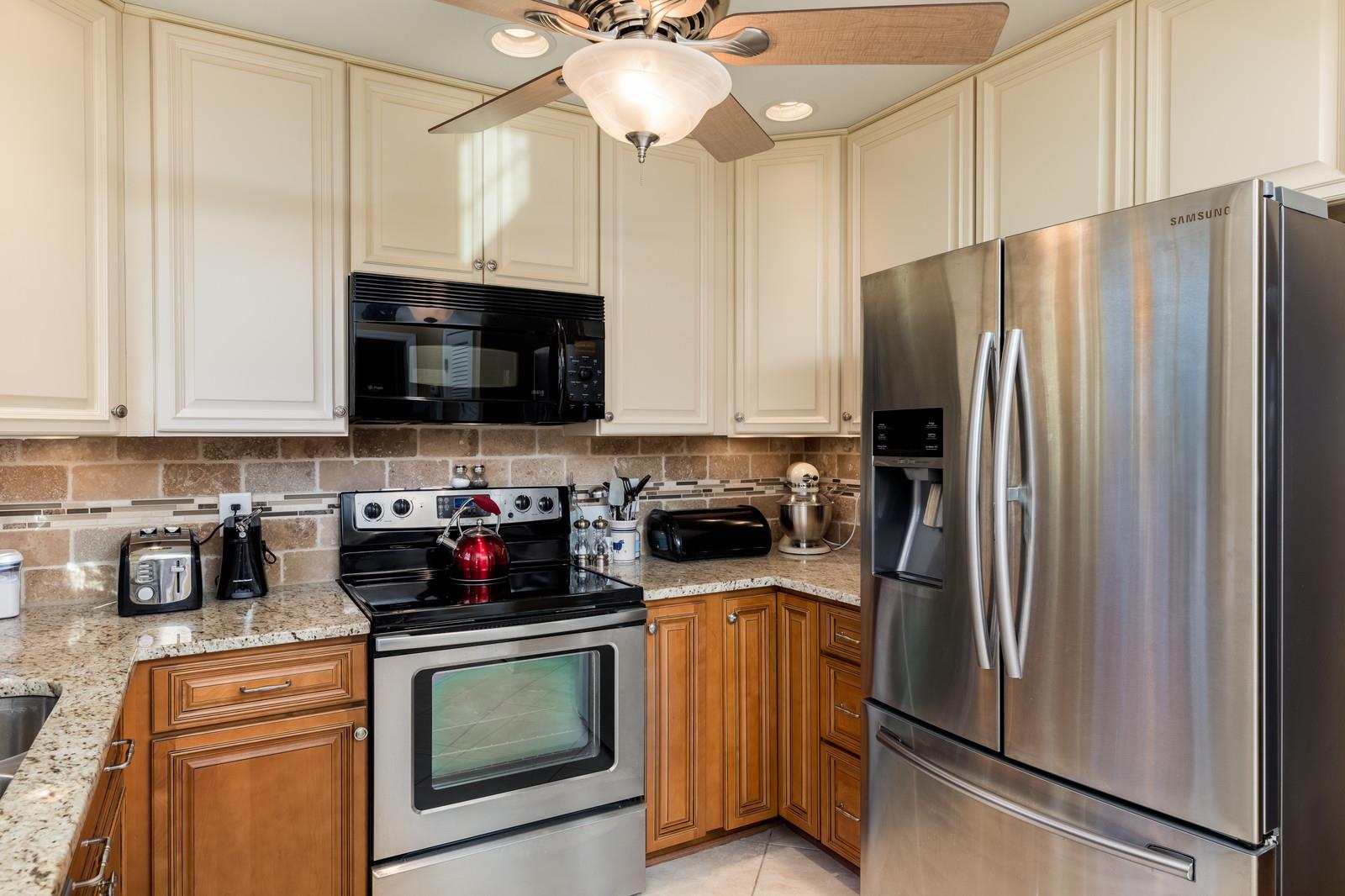 1306 General George Patton Road, Unit 1306 Nashville, TN 37221 - Photo 5 of 21 a kitchen with stainless steel appliances granite countertop a refrigerator a stove a microwave and cabinets
