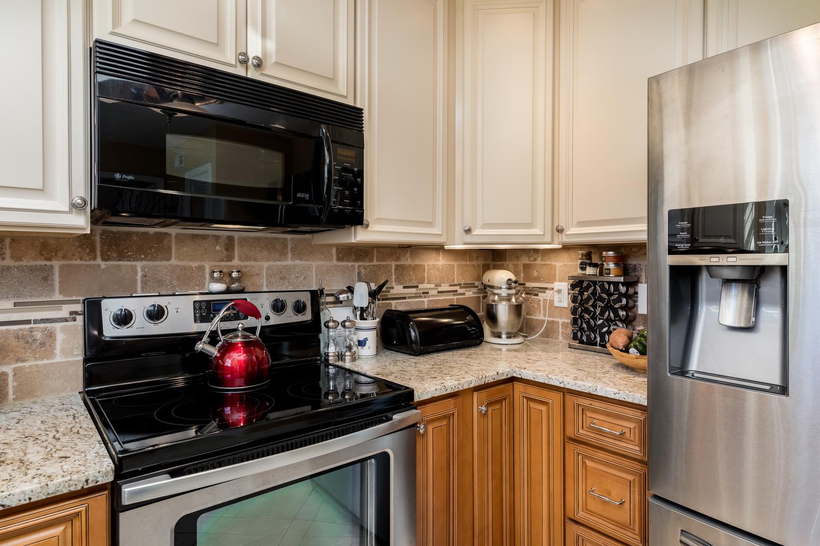 1306 General George Patton Road, Unit 1306 Nashville, TN 37221 - Photo 7 of 21 a kitchen with stainless steel appliances granite countertop a stove and a microwave