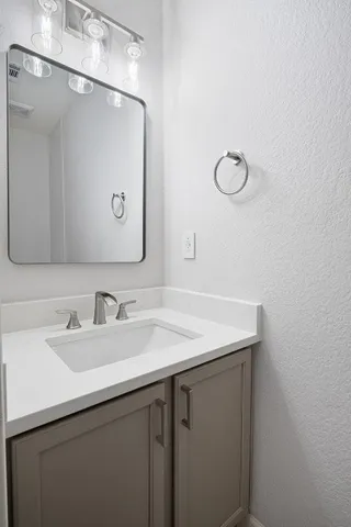 a bathroom with a sink vanity and a mirror