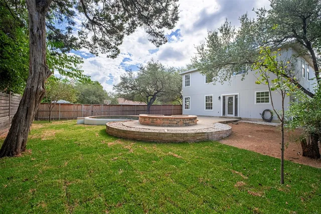 a view of a house with a backyard and a tree