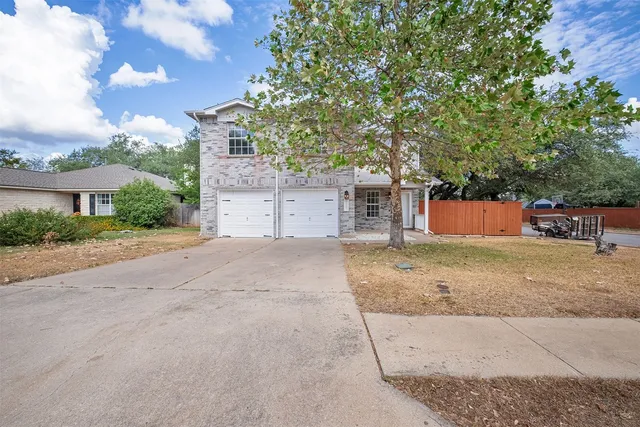 front view of a house with a yard and a garage
