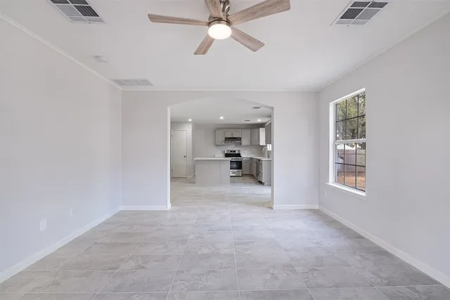 a view of a big room with windows and chandelier fan