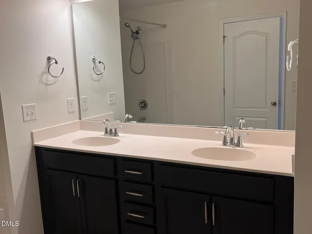 a bathroom with a double vanity sink and a mirror