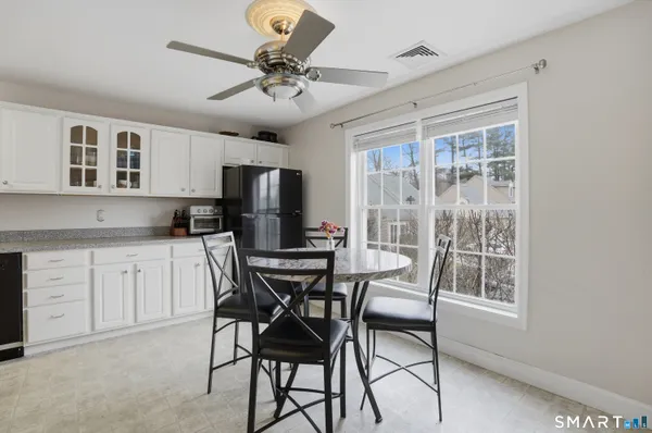 a kitchen with stainless steel appliances granite countertop a stove a refrigerator a sink a stove with a dining table and chairs