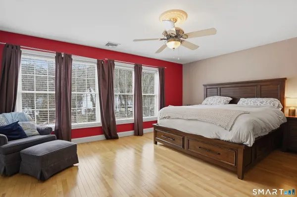 a bed sitting in a spacious bedroom next to a window