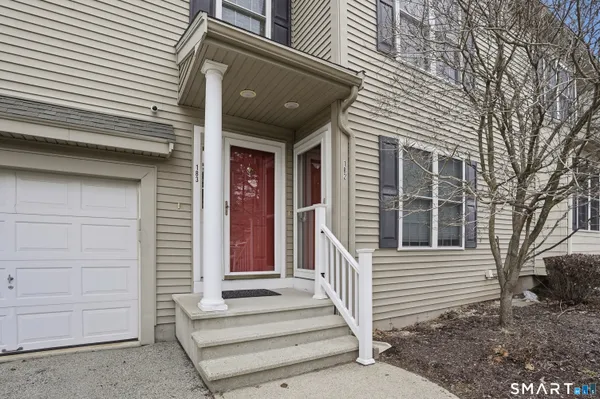 a view of a house with a door and wooden bench