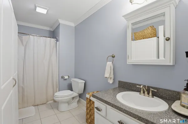 a bathroom with a granite countertop sink toilet and mirror
