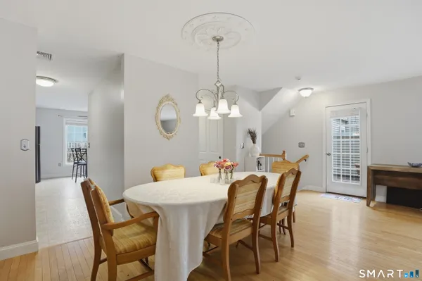 a dining room with furniture a chandelier and wooden floor