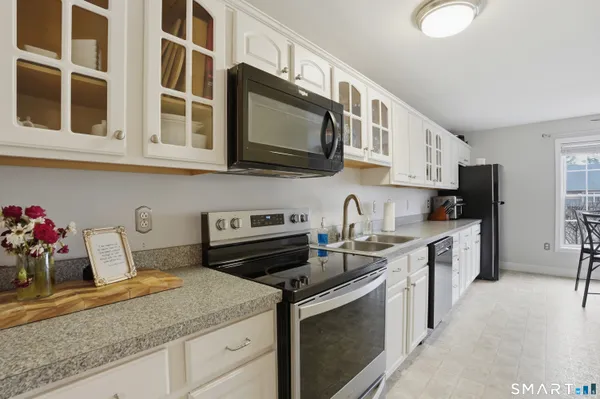 a kitchen with stainless steel appliances granite countertop a sink stove and cabinets