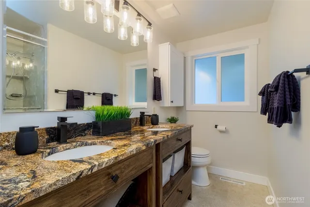 a bathroom with a granite countertop sink and a mirror