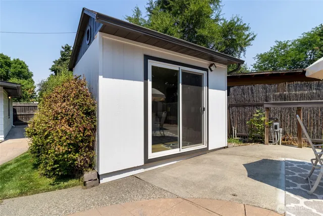 a view of a backyard with plants and a large tree