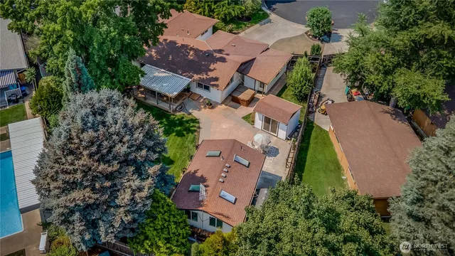 an aerial view of a house with a yard and a large tree