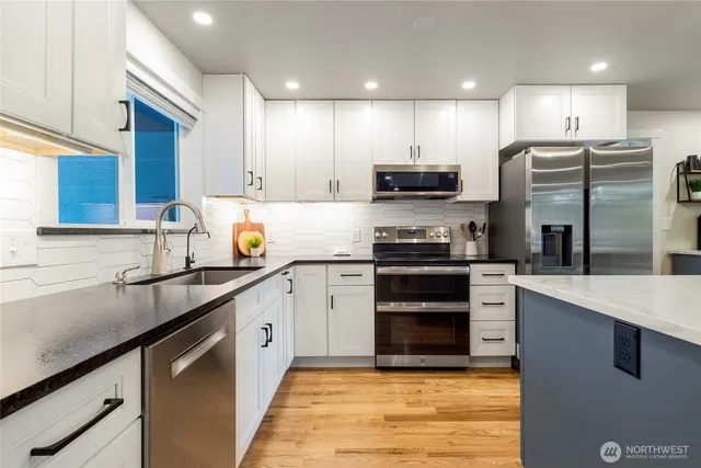 a kitchen with stainless steel appliances granite countertop a sink stove and refrigerator