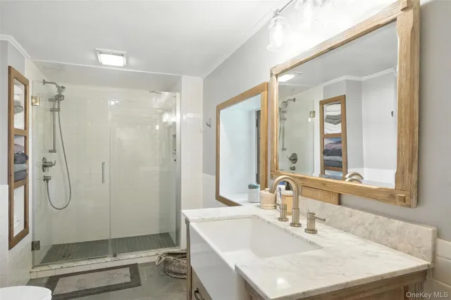 a bathroom with a shower sink vanity and mirror