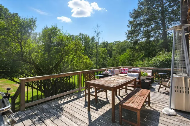 a balcony with wooden floor table and chairs