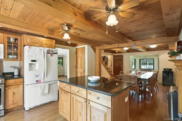 a kitchen with stainless steel appliances kitchen island granite countertop a table chairs and a chandelier