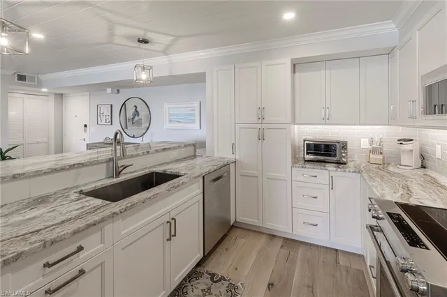 a kitchen with granite countertop a sink a stove and cabinets