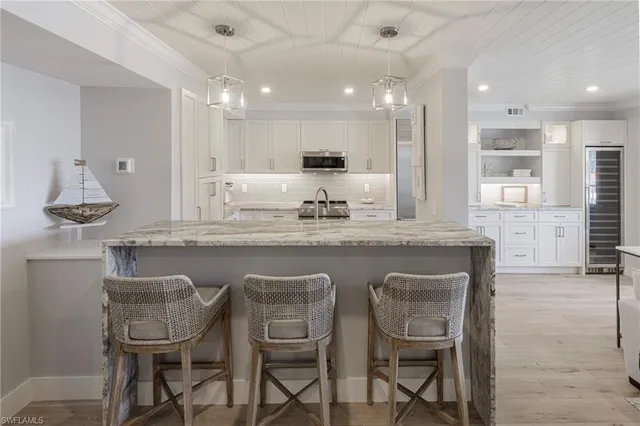 a kitchen with granite countertop kitchen island cabinets and chairs in it