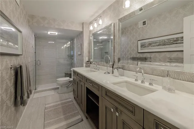 a bathroom with a double vanity sink a toilet and a mirror