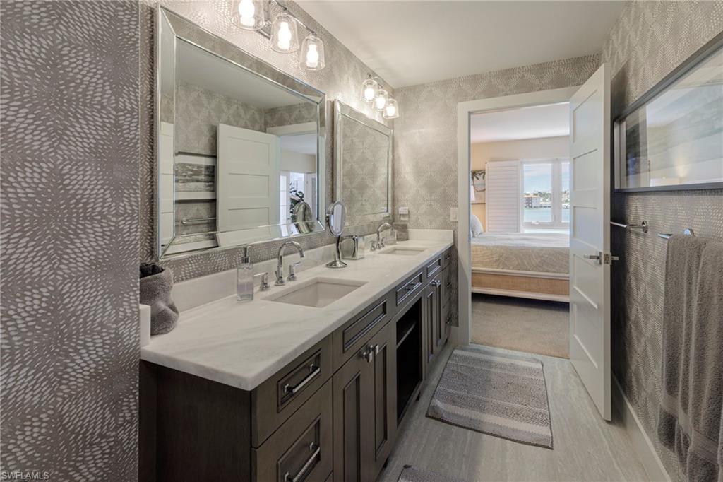 250 Park Shore Drive, Unit 302 Naples, FL 34103 - Photo 19 of 35 a bathroom with a sink and a mirror