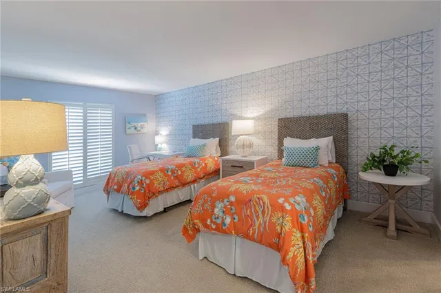 a bedroom with two beds and potted plant