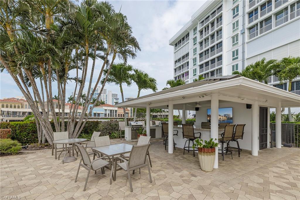 250 Park Shore Drive, Unit 302 Naples, FL 34103 - Photo 35 of 35 a view of a patio with a table and chairs and potted plants