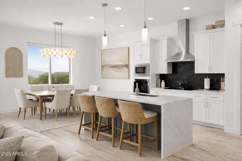 a kitchen with kitchen island granite countertop a table chairs sink and cabinets