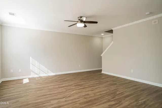 a view of a room with wooden floor and white walls