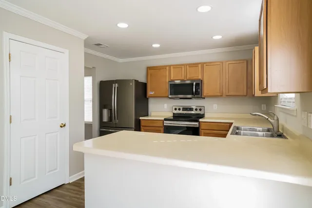 a kitchen with stainless steel appliances a refrigerator a sink a stove a microwave and cabinets