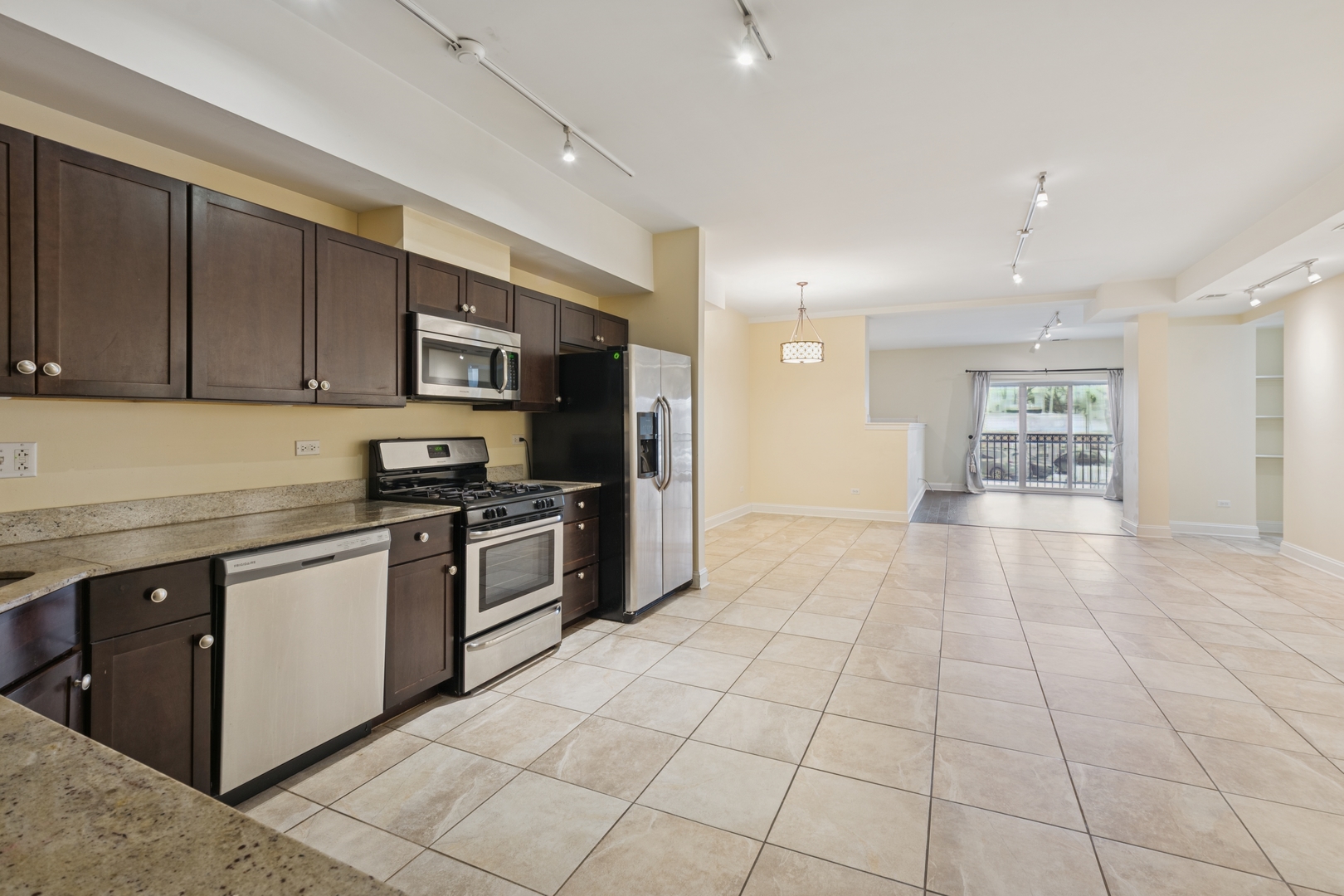 2801 West Ardmore Avenue, Unit 1A Chicago, IL 60659 - Photo 13 of 22 a large kitchen with stainless steel appliances granite countertop a stove and a refrigerator