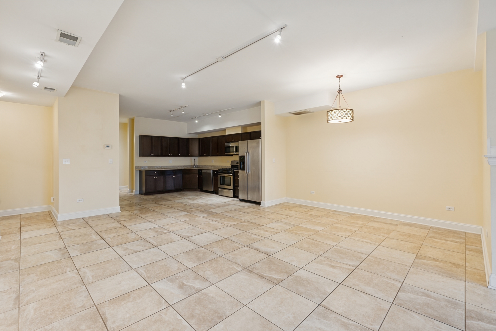 2801 West Ardmore Avenue, Unit 1A Chicago, IL 60659 - Photo 21 of 22 an empty room with kitchen view and natural light