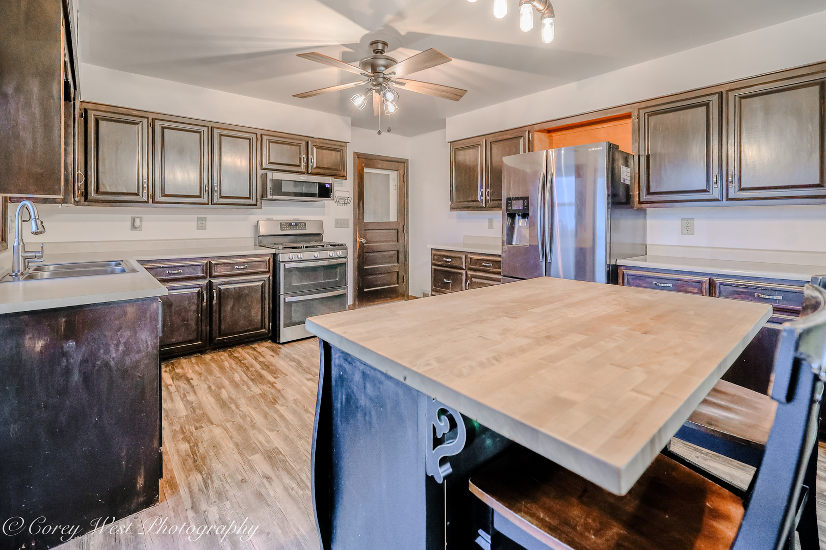 8994 Highway 64 Sycamore, IL 60178 - Photo 12 of 37 a kitchen with stainless steel appliances kitchen island granite countertop a stove top oven a sink dishwasher a dining table and chairs with wooden floor
