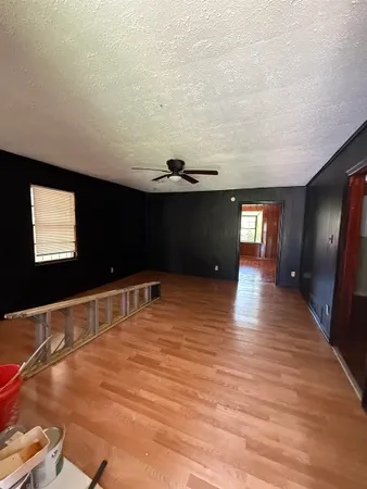 a view of empty room with window and wooden floor