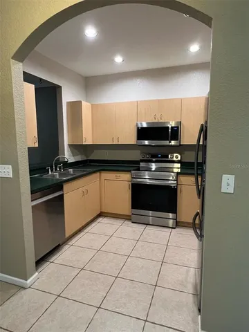 a kitchen with granite countertop a stove sink and cabinets