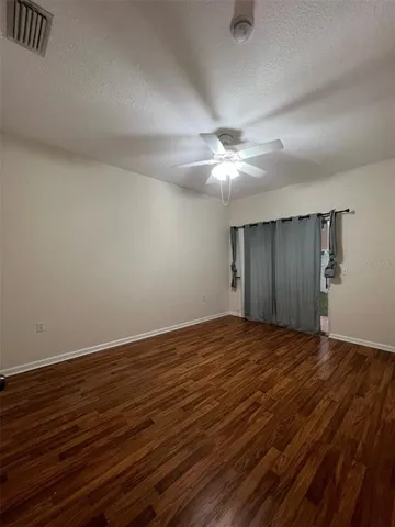 a view of an empty room with wooden floor