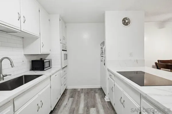 a kitchen with a sink dishwasher a refrigerator and cabinets