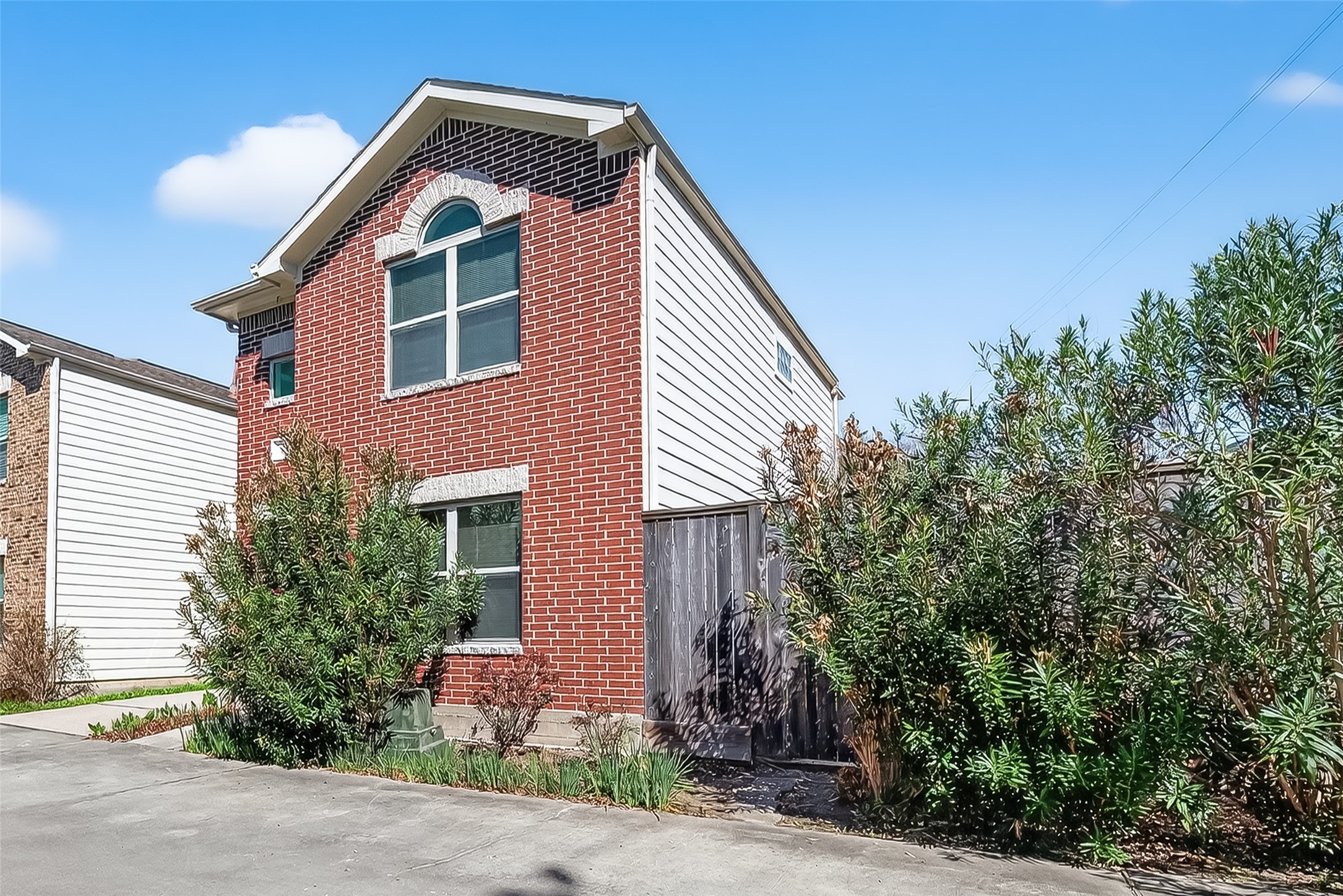 5951 S Loop East, Unit 47 Houston, TX 77033 - Photo 2 of 37 This modern two-story townhome features large windows and is surrounded by greenery, offering a welcoming and well-maintained exterior.
