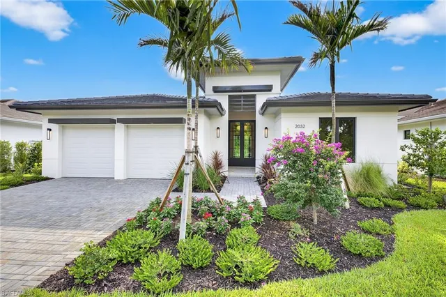 a front view of a house with a yard and potted plants