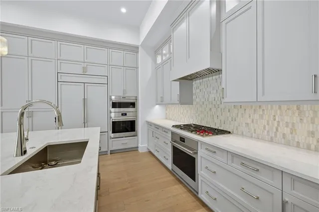 a kitchen with granite countertop white cabinets and appliances