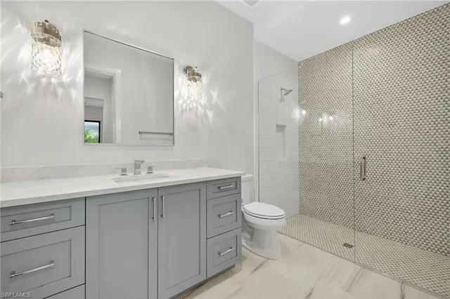 a bathroom with a double vanity sink toilet and shower