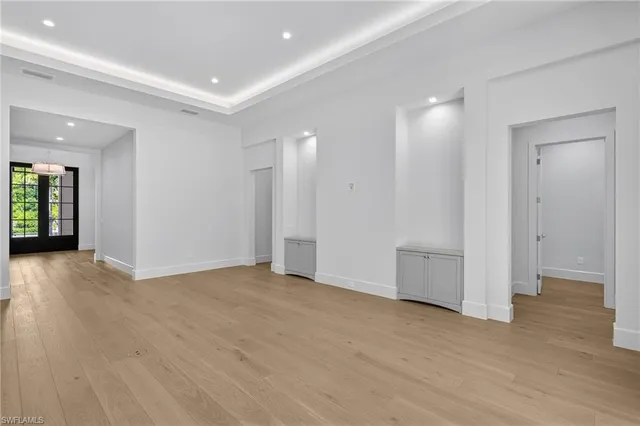 an empty room with wooden floor & windows