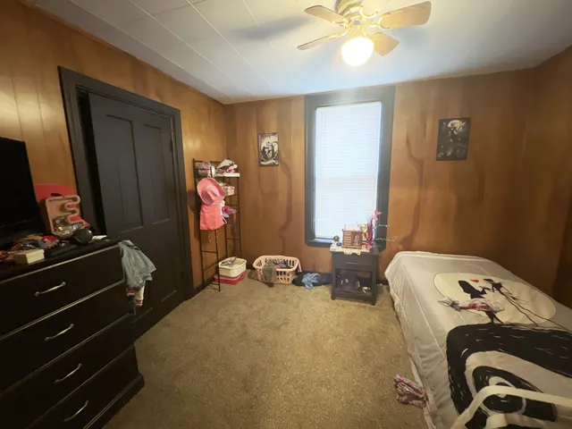 a bedroom with bed and a mirror