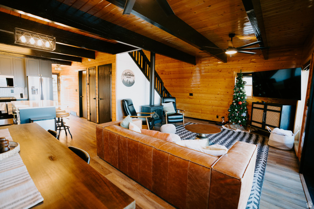 1413 Basel Drive Midway, UT 84049 - Photo 8 of 137 Living room featuring wood walls, light wood-style floors, a wooden ceiling with exposed beams, and ceiling fan