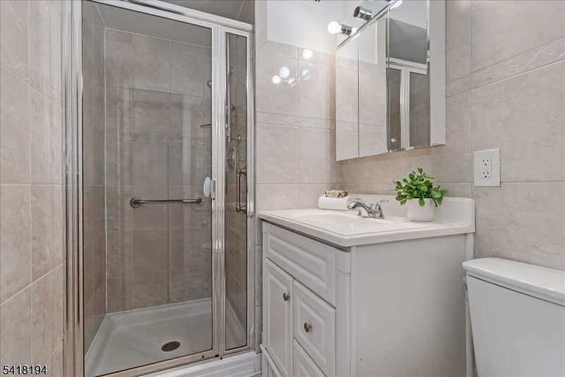 530 Valley Road, Unit 3L Montclair, NJ 07043 - Photo 17 of 25 a bathroom with a shower sink and mirror