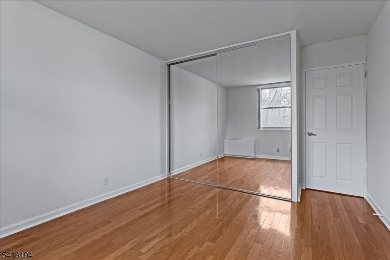 530 Valley Road, Unit 3L Montclair, NJ 07043 - Photo 18 of 25 an empty room with wooden floor and windows