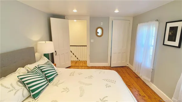 a bedroom with a bed and painting on the wall