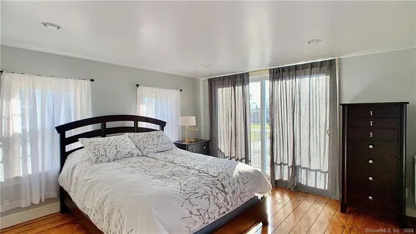 a bedroom with a bed a mirror and a window