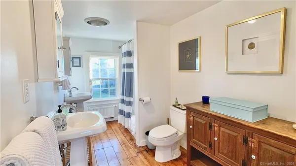 a bathroom with a toilet a sink and mirror