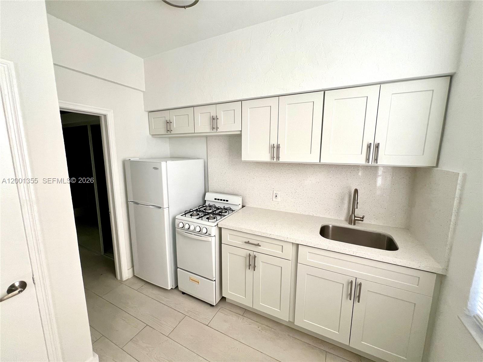 135 3rd Street, Unit 25 Miami Beach, FL 33139 - Photo 7 of 12 a kitchen with stainless steel appliances a refrigerator sink and cabinets